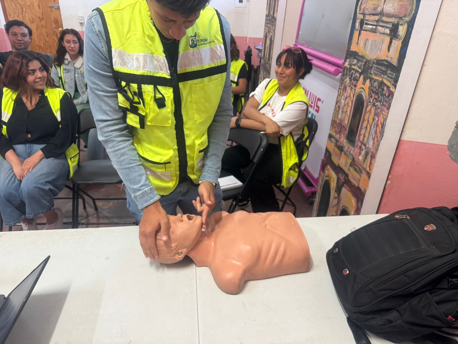 Fotografía de una persona con un maniquí de RCP